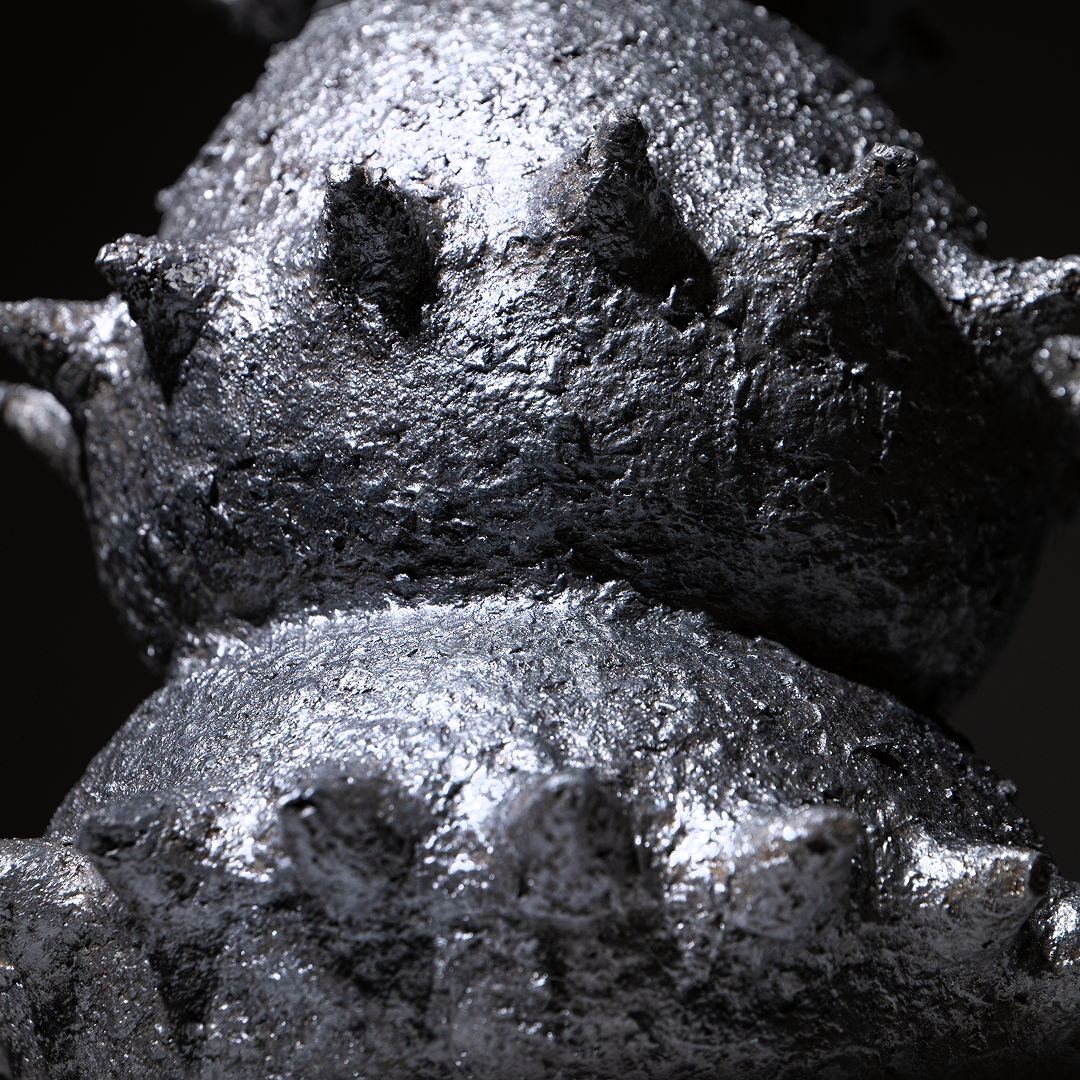 Close-up of the textured, spiked surface of the handbuilt papier-mâché sculptural vessel “Tálä” by Pulp Fictitious in a silver finish. 